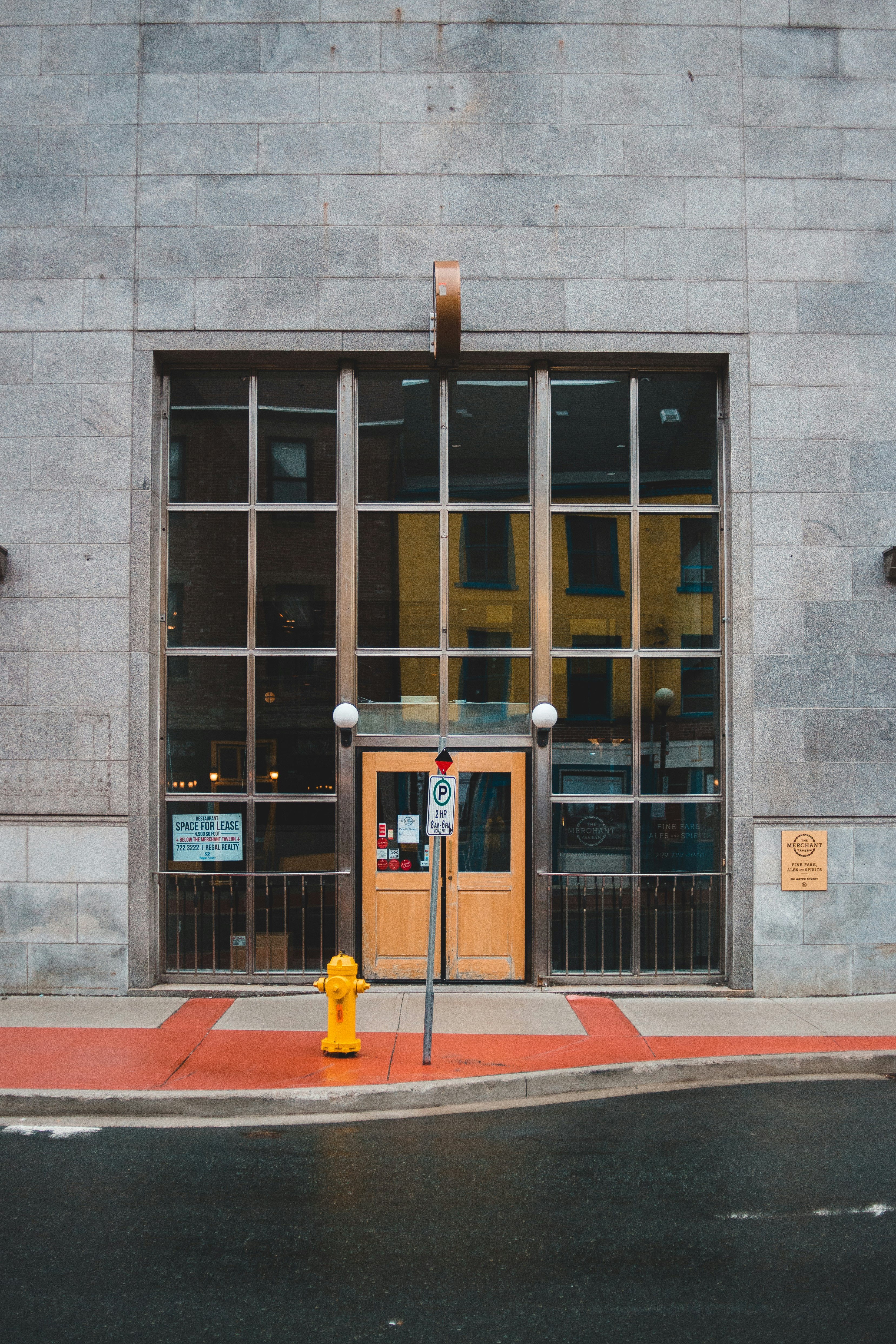 red fire extinguisher beside brown and white concrete building